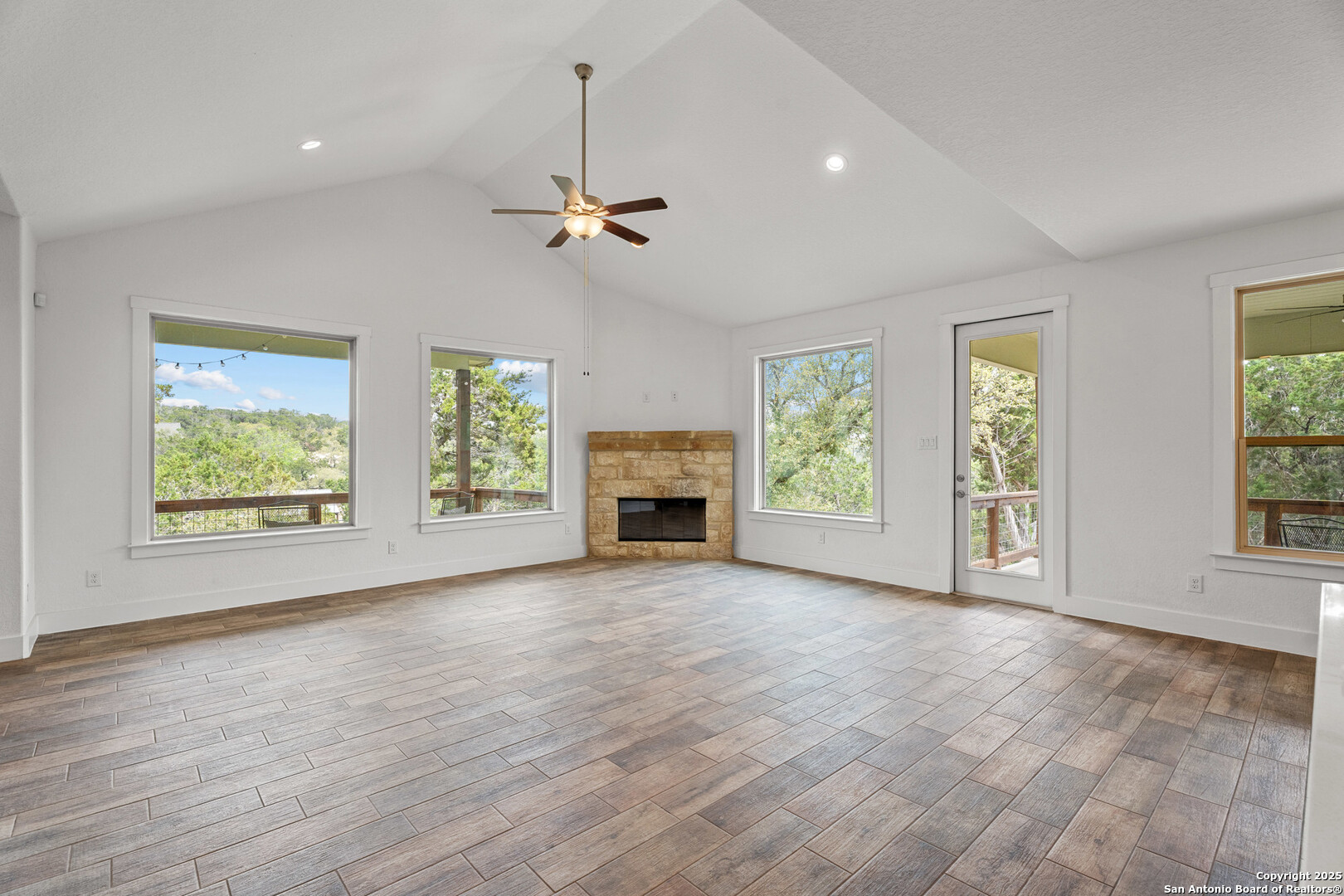 1039 Primrose Path Spring Branch, TX 78070 - Photo 10 of 30 an empty room with windows fireplace and wooden floor