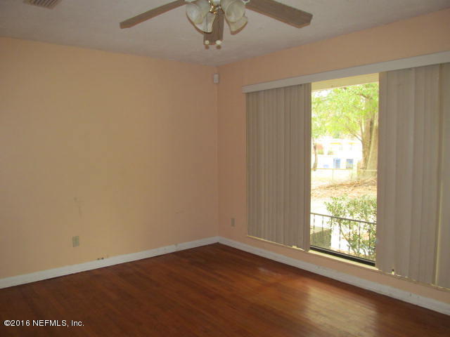 6718 Corday Road Jacksonville, FL 32208 - Photo 5 of 14 a view of an empty room with wooden floor and a window