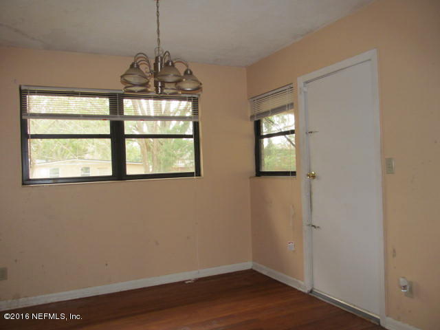 6718 Corday Road Jacksonville, FL 32208 - Photo 6 of 14 a view of an empty room with wooden floor and a window