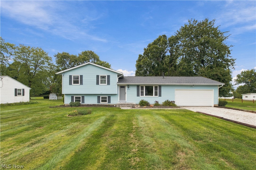 5972 Keller Road Akron, OH 44319 - Photo 1 of 29 Split-level exterior with light blue siding, dark shutters, and an attached garage