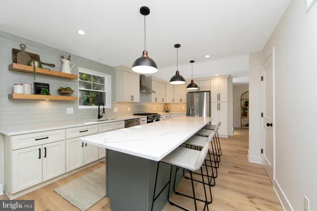 a kitchen with stainless steel appliances a sink a stove a refrigerator and cabinets
