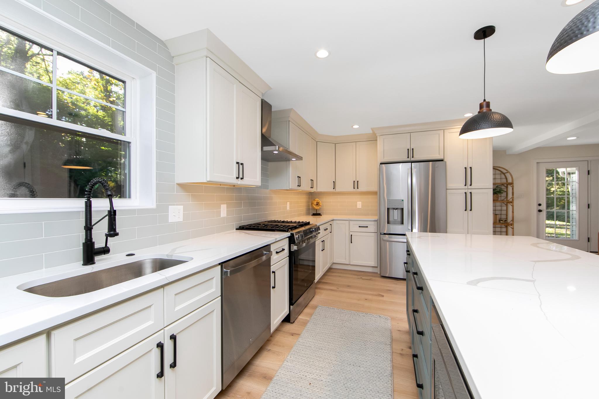 22 Scenic Road Springfield, PA 19064 - Photo 14 of 56 a large kitchen with stainless steel appliances kitchen island granite countertop a sink and a refrigerator
