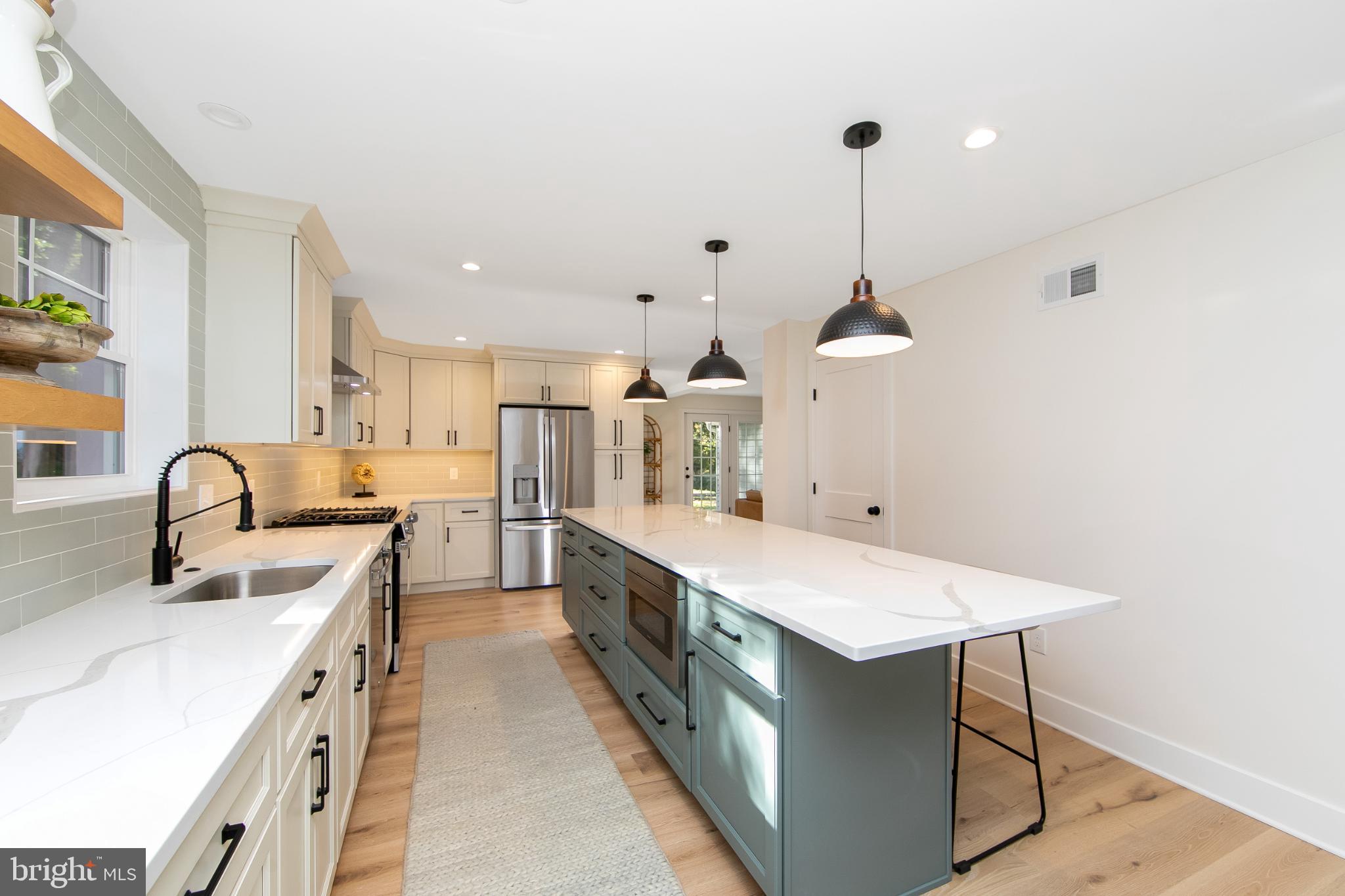 22 Scenic Road Springfield, PA 19064 - Photo 15 of 56 a large kitchen with kitchen island a sink a counter space and stainless steel appliances