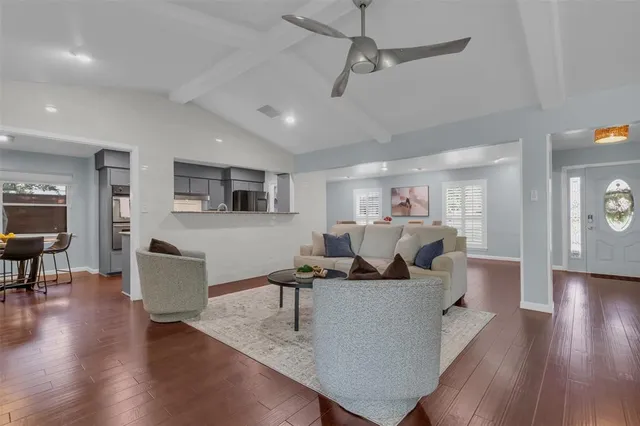 a living room with furniture and a wooden floor