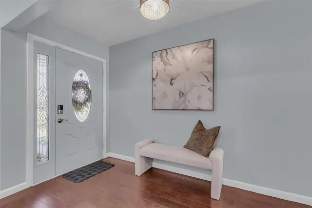 a view of an empty room with wooden floor and window