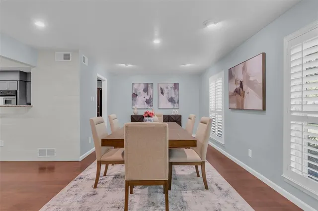 a view of a dining room with furniture a rug and wooden floor