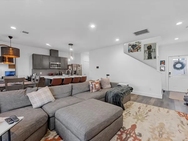 a living room with furniture and a view of kitchen