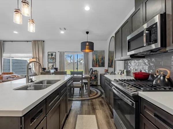 a kitchen with stainless steel appliances a sink a stove and cabinets