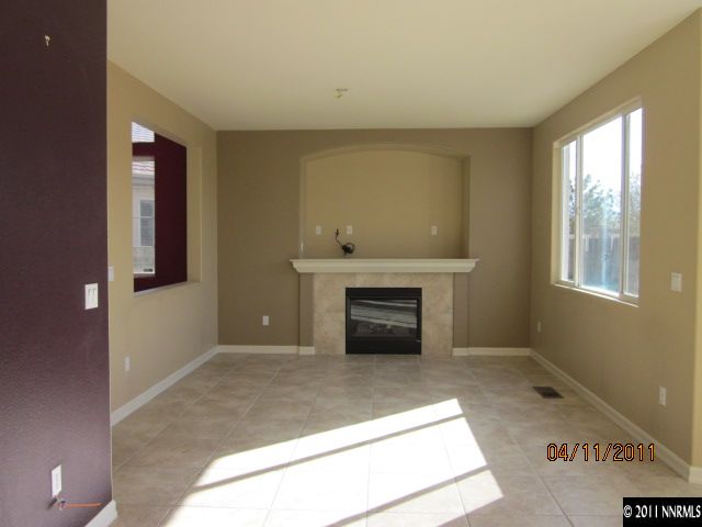 9931 Northrup Drive Reno, NV 89521 - Photo 4 of 8 a view of an empty room with a fireplace and a window