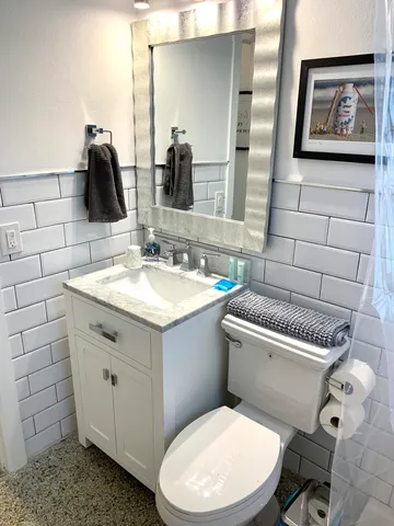a bathroom with a toilet sink and mirror