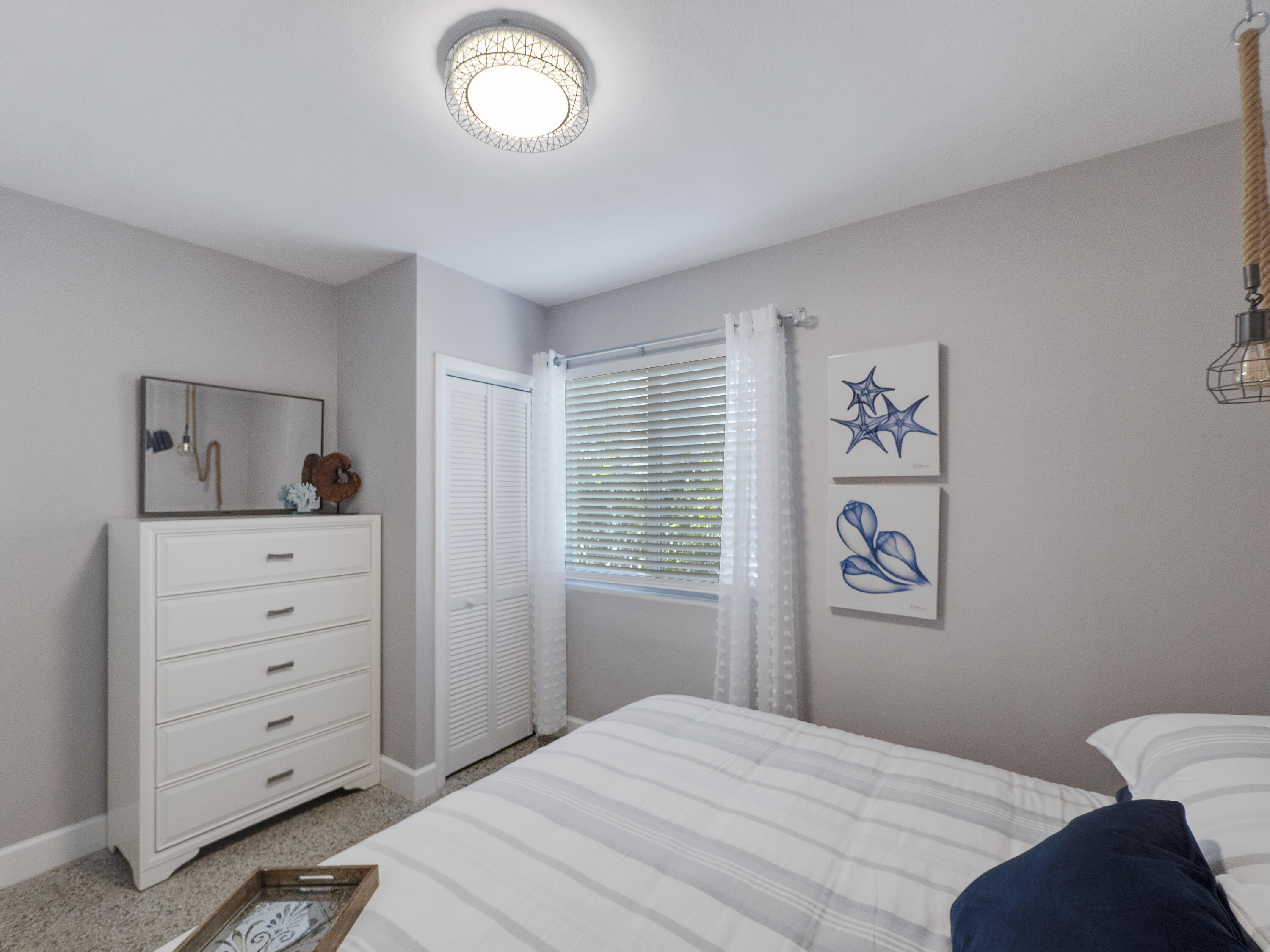 1258 Beach Road, Unit 5 Singer Island, FL 33404 - Photo 4 of 12 a bedroom with a bed and a dresser in it