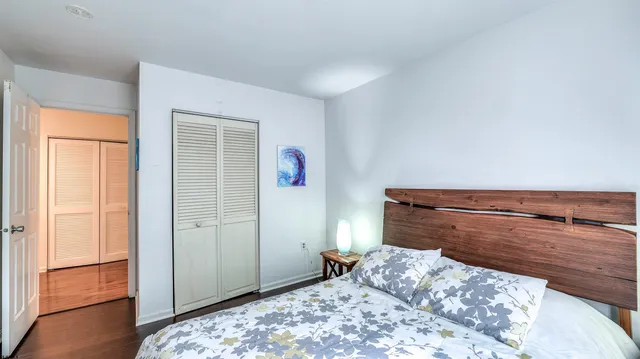 a bedroom with a bed and wooden floor