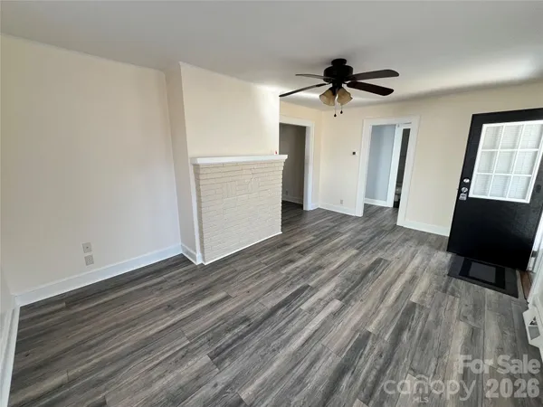 a view of a livingroom with wooden floor and a ceiling fan