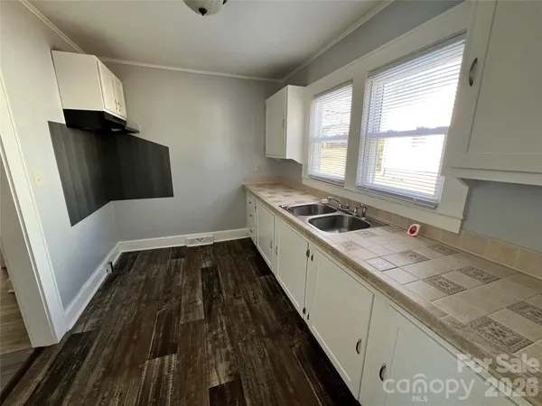 a kitchen with a sink and wooden floor