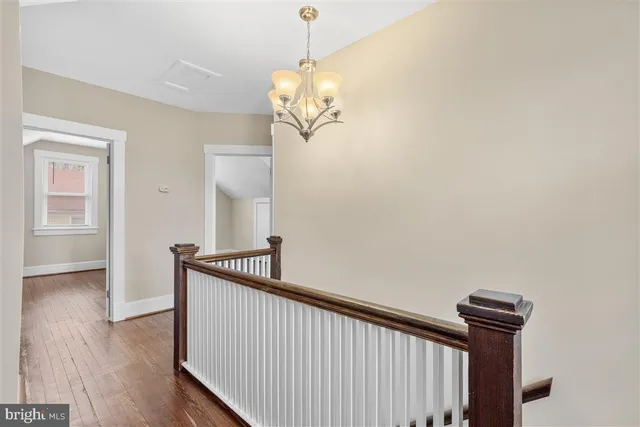 a view of a hallway with wooden floor and staircase