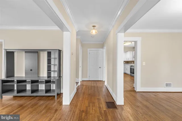 a view of a room with wooden floor and entryway