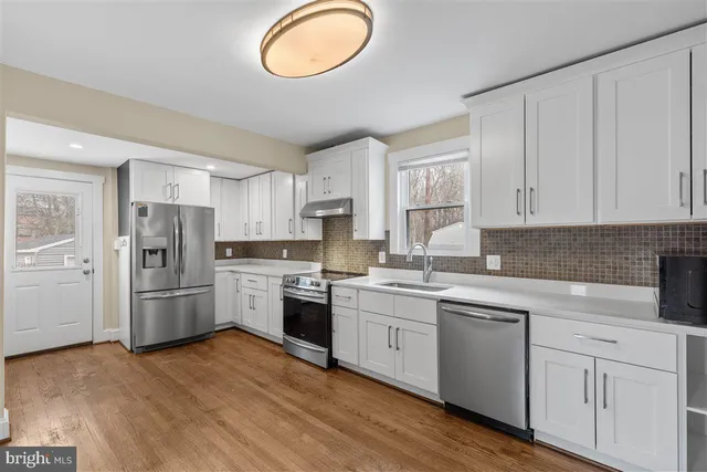 a kitchen with cabinets stainless steel appliances and a window