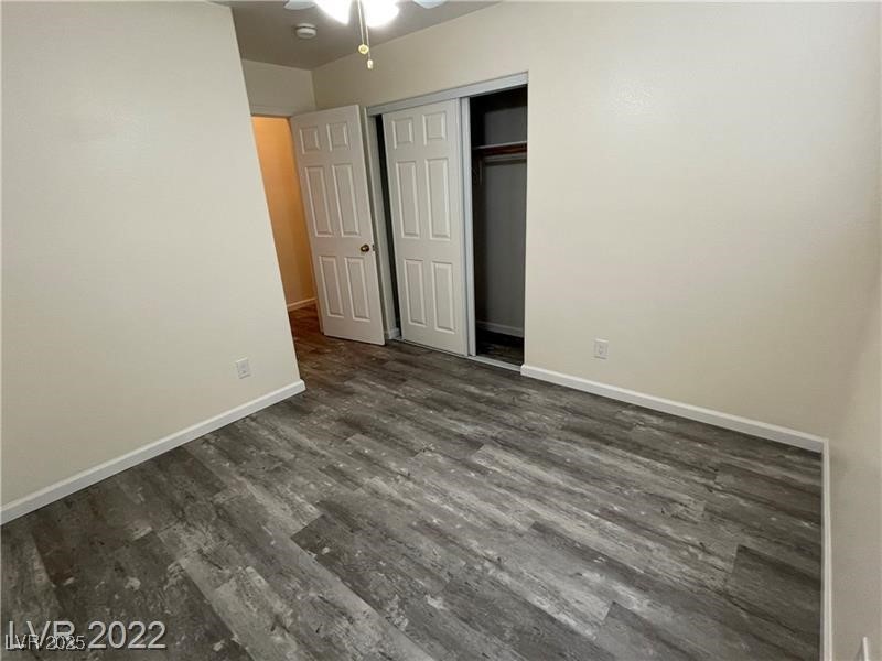 838 Rusty Anchor Way Henderson, NV 89002 - Photo 15 of 18 Unfurnished bedroom featuring dark wood-style floors, a ceiling fan, and a closet