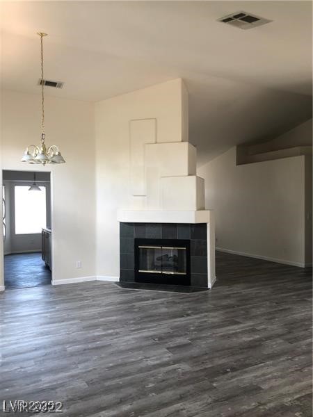 838 Rusty Anchor Way Henderson, NV 89002 - Photo 5 of 18 Unfurnished living room featuring dark wood-type flooring, a tile fireplace, and a chandelier