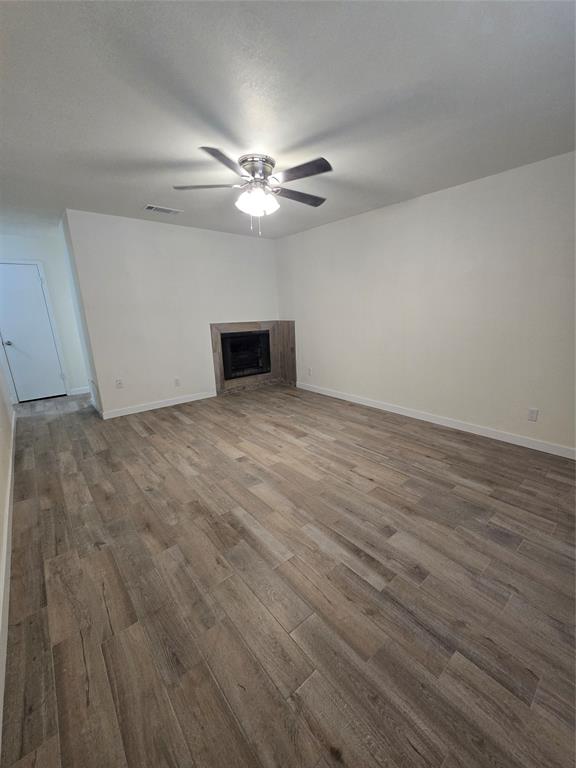 1012 Lynn Street, Unit A Weatherford, TX 76086 - Photo 2 of 15 an empty room with wooden floor fan and windows