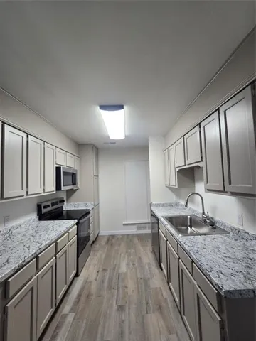 a kitchen with granite countertop a sink stove and refrigerator