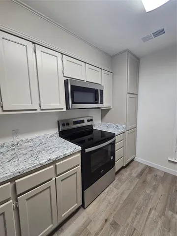 a kitchen with granite countertop a sink cabinets and stainless steel appliances