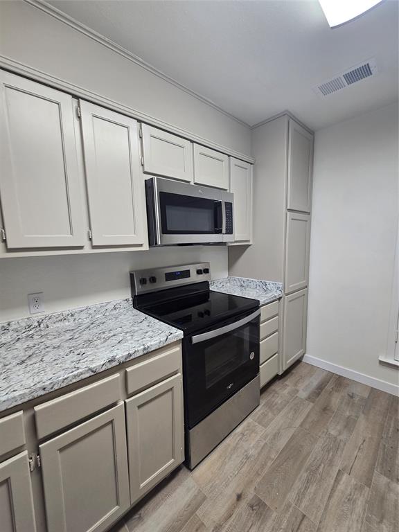 1012 Lynn Street, Unit A Weatherford, TX 76086 - Photo 9 of 15 a kitchen with granite countertop a sink cabinets and stainless steel appliances