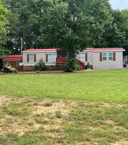 a front view of a house with a yard and trees