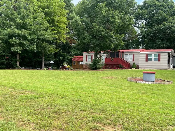 a view of a house with a big yard and large trees
