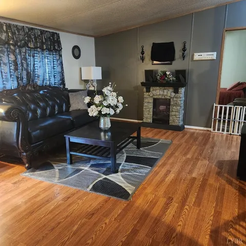 a living room with furniture a flat screen tv and a table