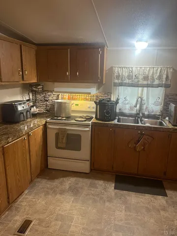 a kitchen with a sink a stove and cabinets