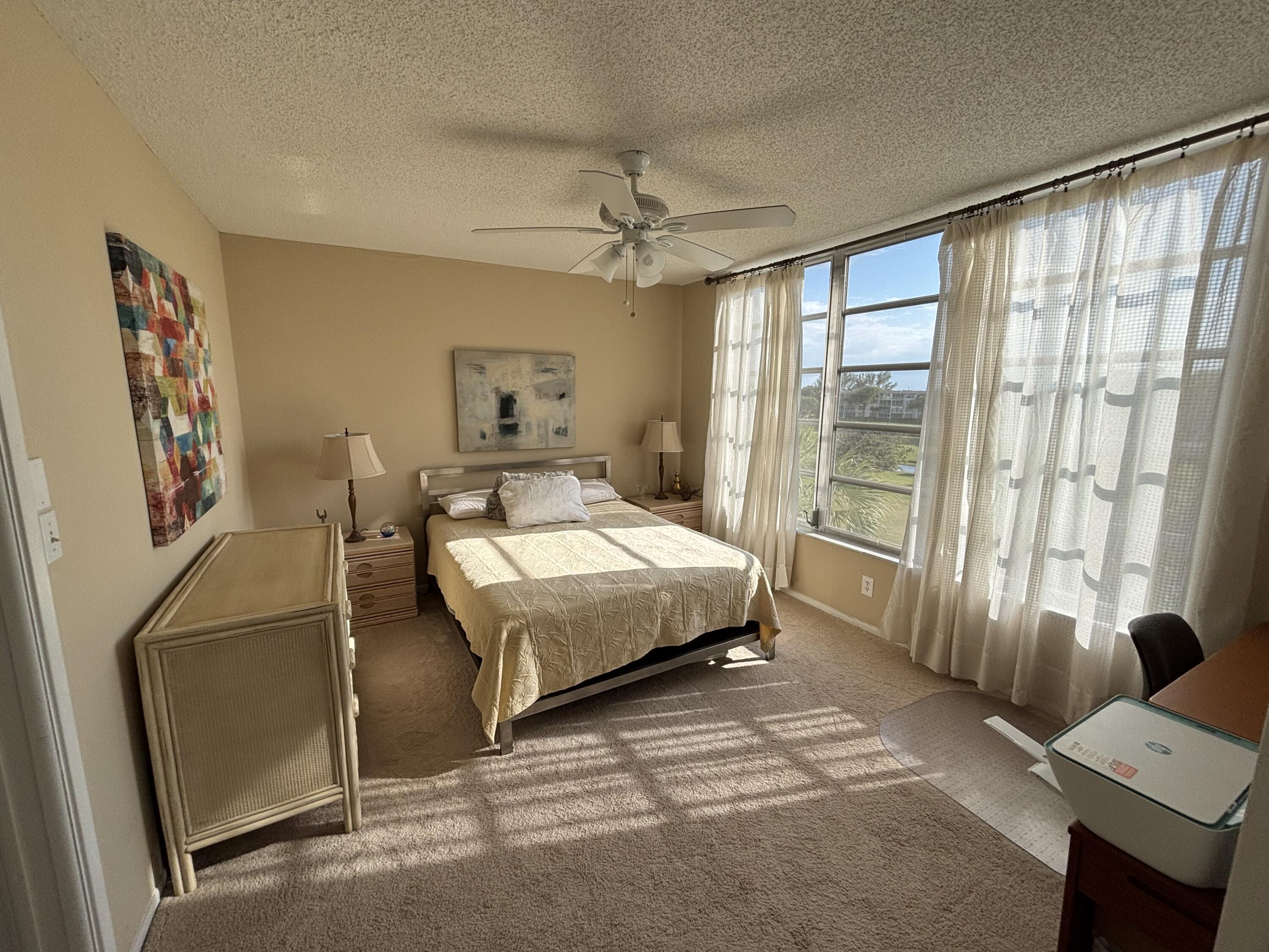 2691 South Course Drive, Unit 408 Pompano Beach, FL 33069 - Photo 18 of 24 a bedroom with a bed window and a flat screen tv
