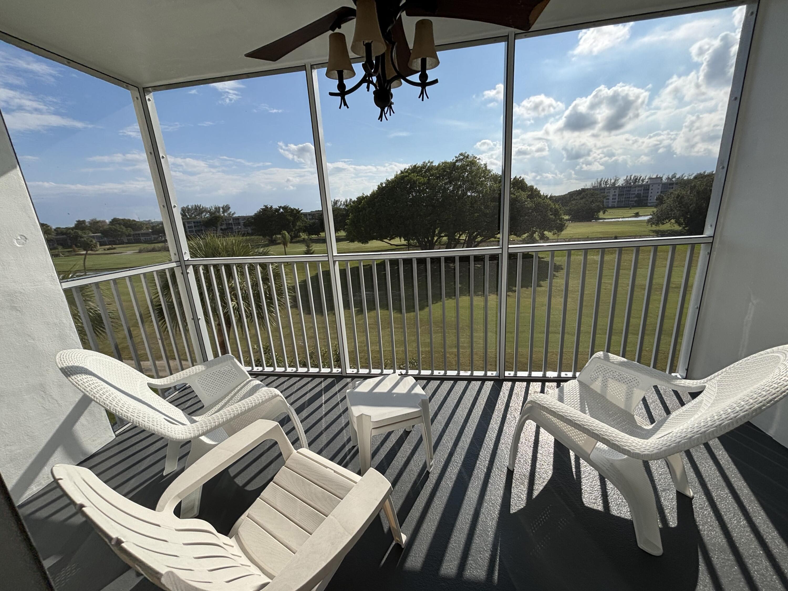 2691 South Course Drive, Unit 408 Pompano Beach, FL 33069 - Photo 19 of 24 a view of balcony with wooden floor and outdoor seating