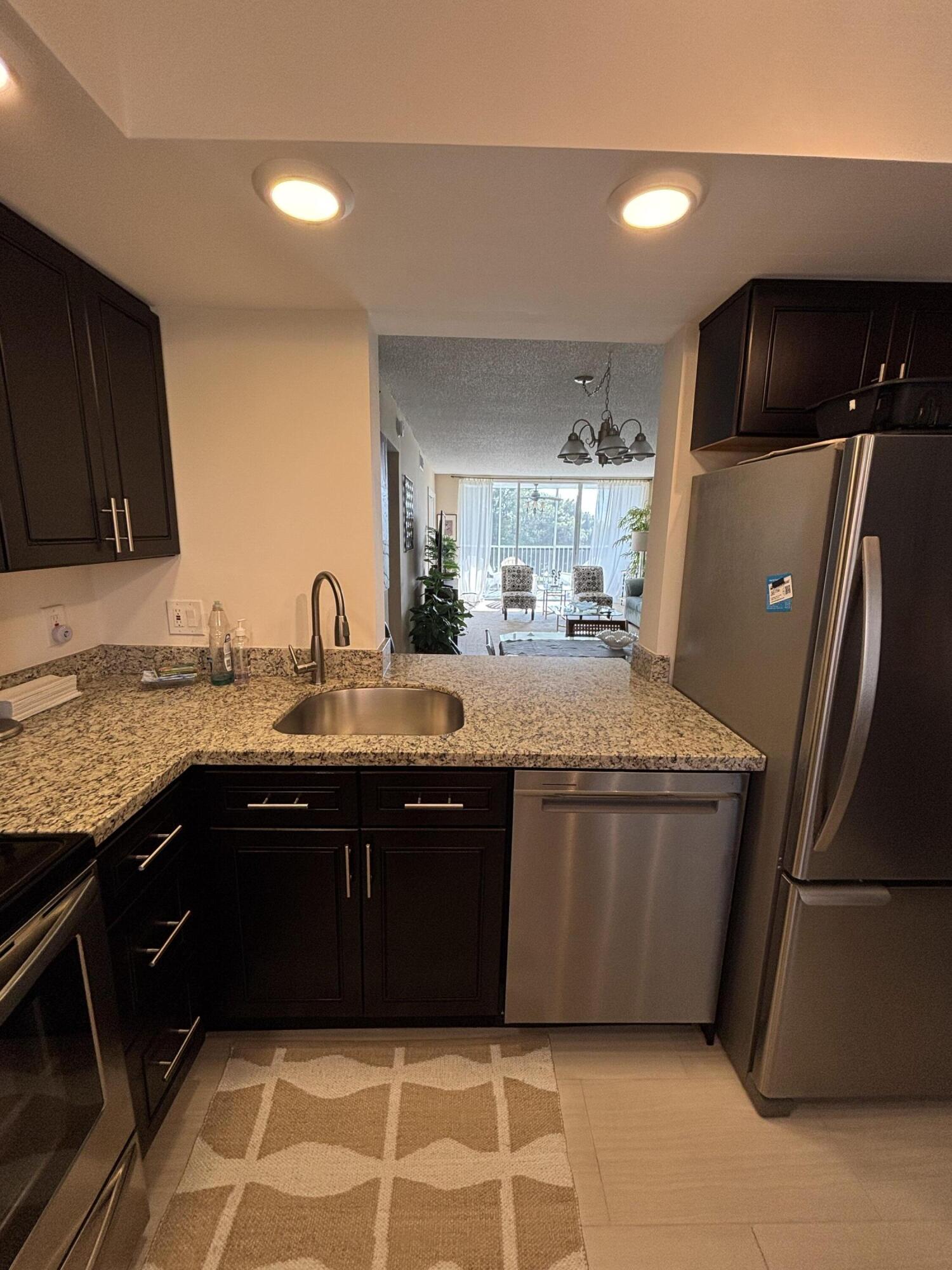 2691 South Course Drive, Unit 408 Pompano Beach, FL 33069 - Photo 6 of 24 a kitchen with stainless steel appliances granite countertop a sink and a refrigerator