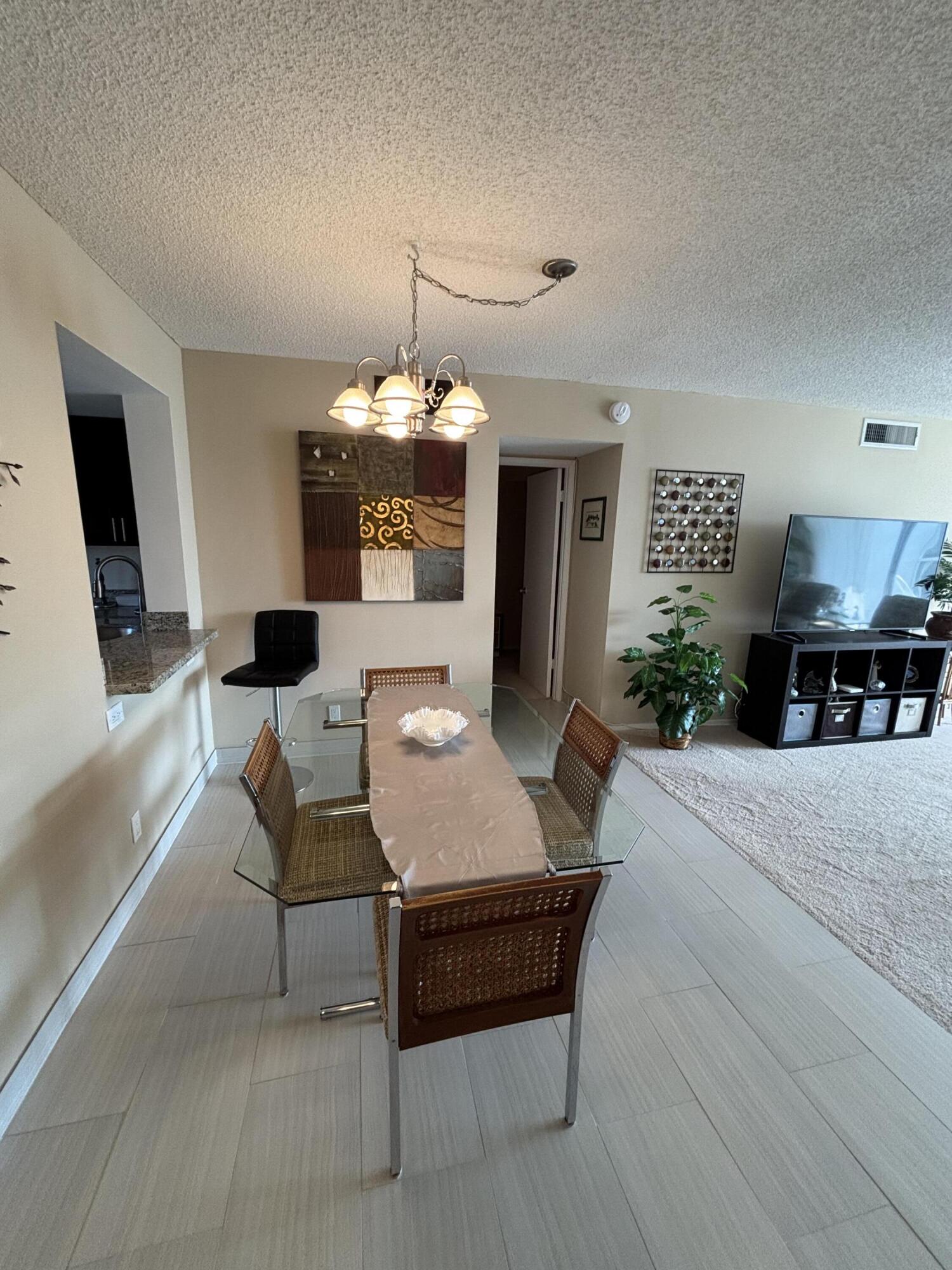 2691 South Course Drive, Unit 408 Pompano Beach, FL 33069 - Photo 8 of 24 a living room with furniture and a chandelier
