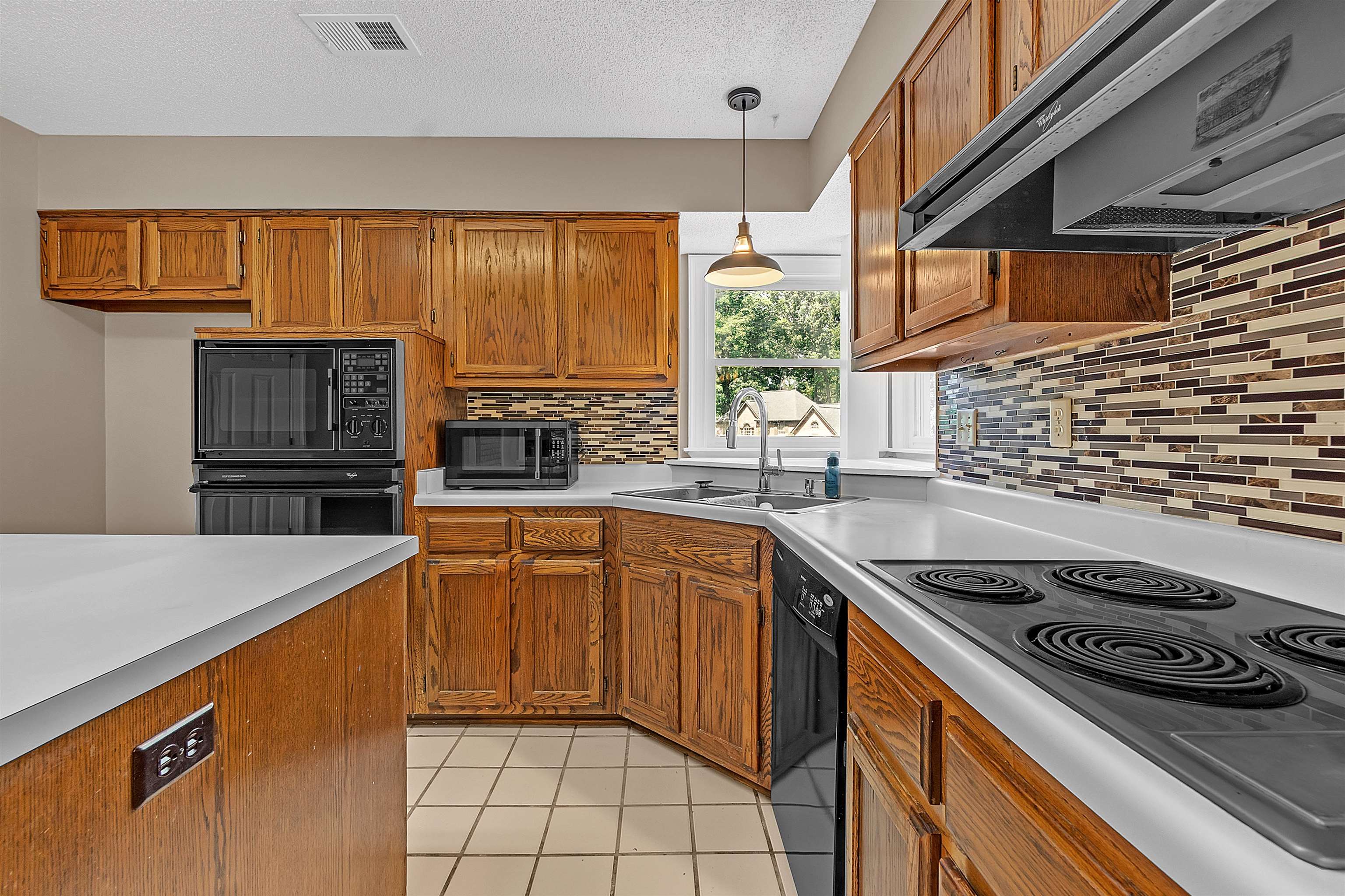 400 Reksten Cove Memphis, TN 38018 - Photo 11 of 26 Kitchen featuring wood cabinetry, white countertops, built-in oven with microwave, electric cooktop, and a mosaic tile backsplash