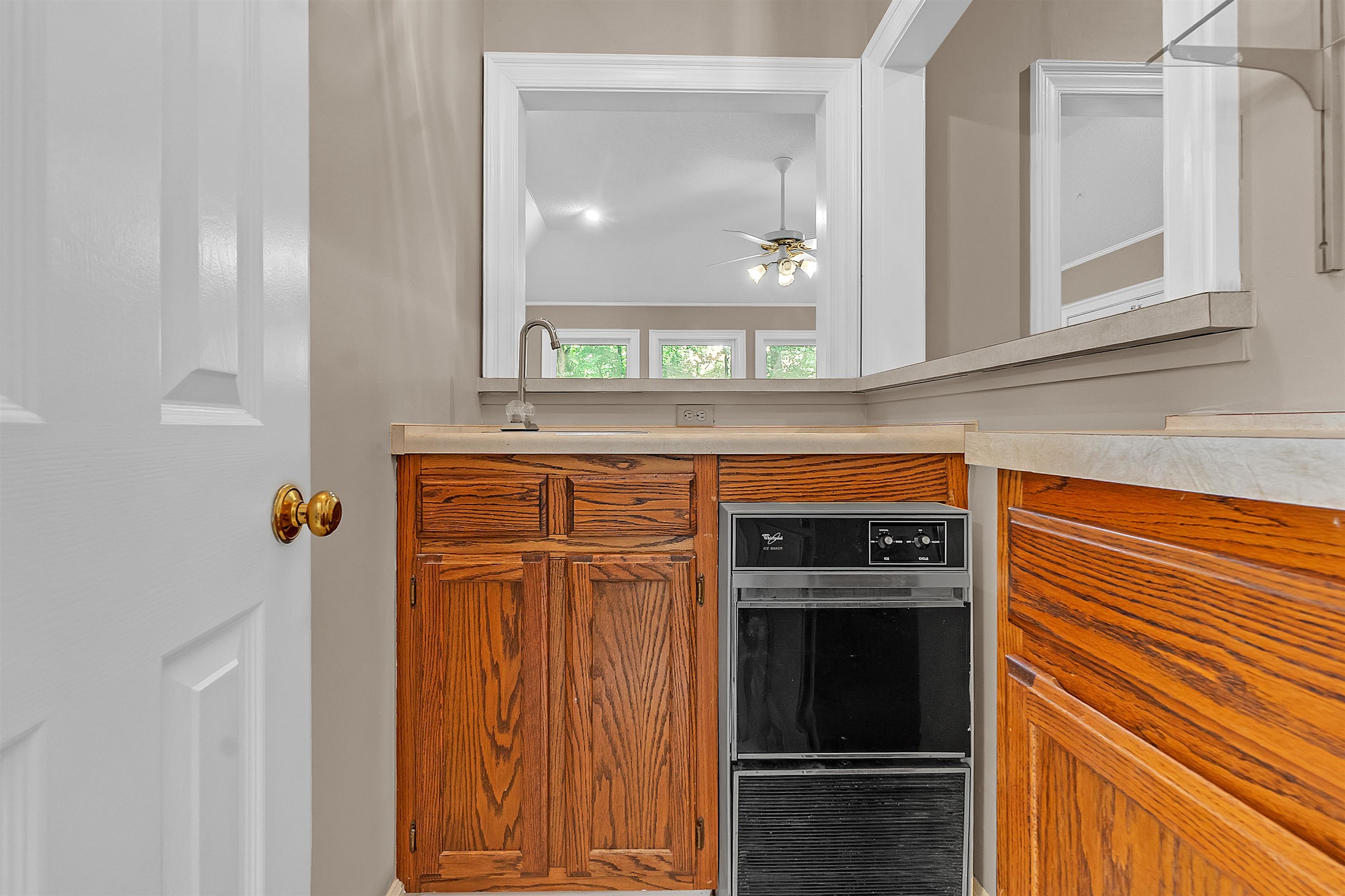 400 Reksten Cove Memphis, TN 38018 - Photo 12 of 26 Built-in wall oven with wood-finish cabinetry, countertop with integrated sink, and an interior pass-through window with trim