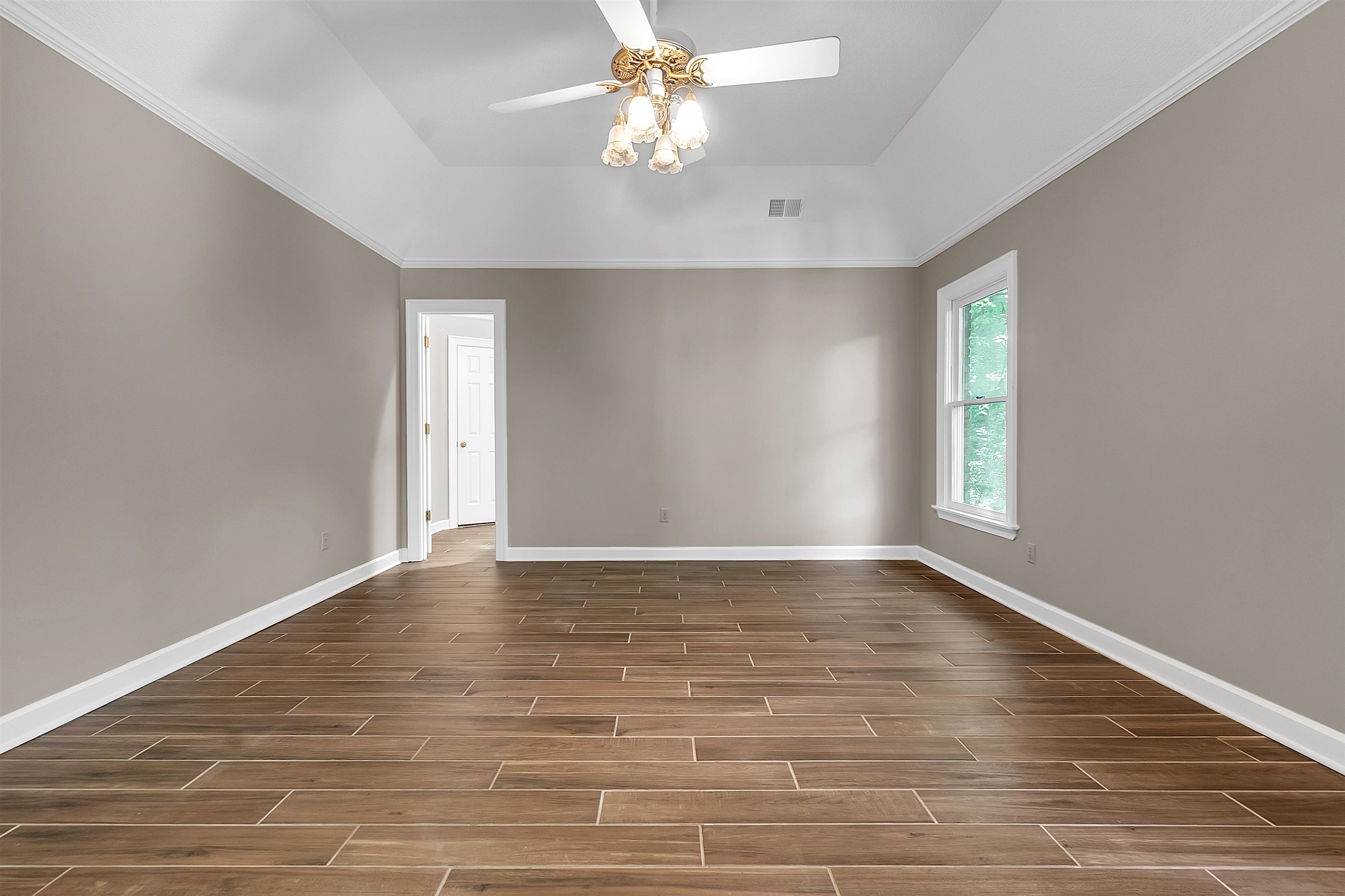 400 Reksten Cove Memphis, TN 38018 - Photo 17 of 26 Spacious room featuring wood-finish tile flooring, a tray ceiling, and a ceiling fan with integrated lighting