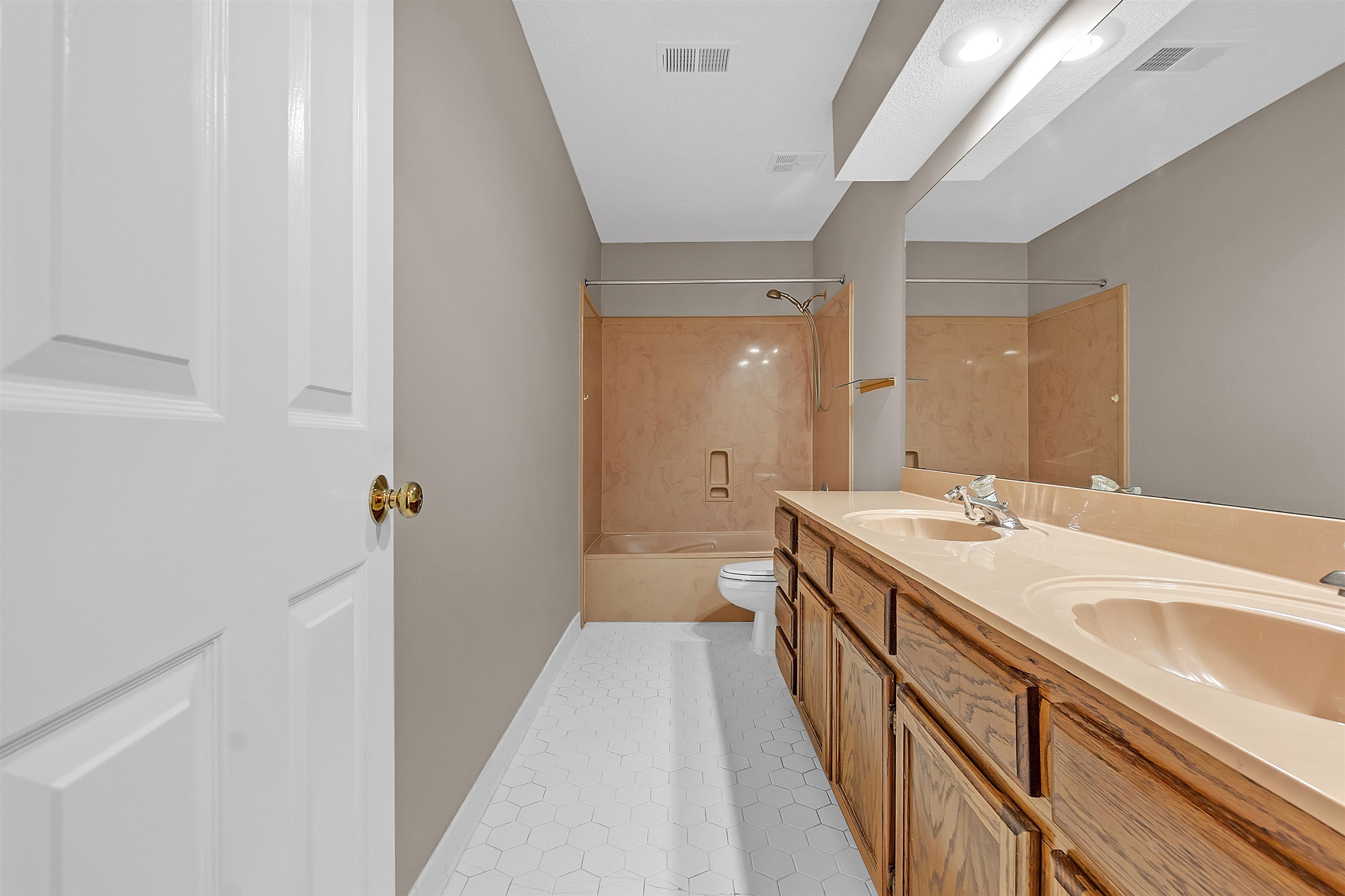 400 Reksten Cove Memphis, TN 38018 - Photo 21 of 26 Bathroom featuring a double vanity with integrated sinks, a full-width mirror, recessed lighting, and a combination tub/shower with a tiled surround