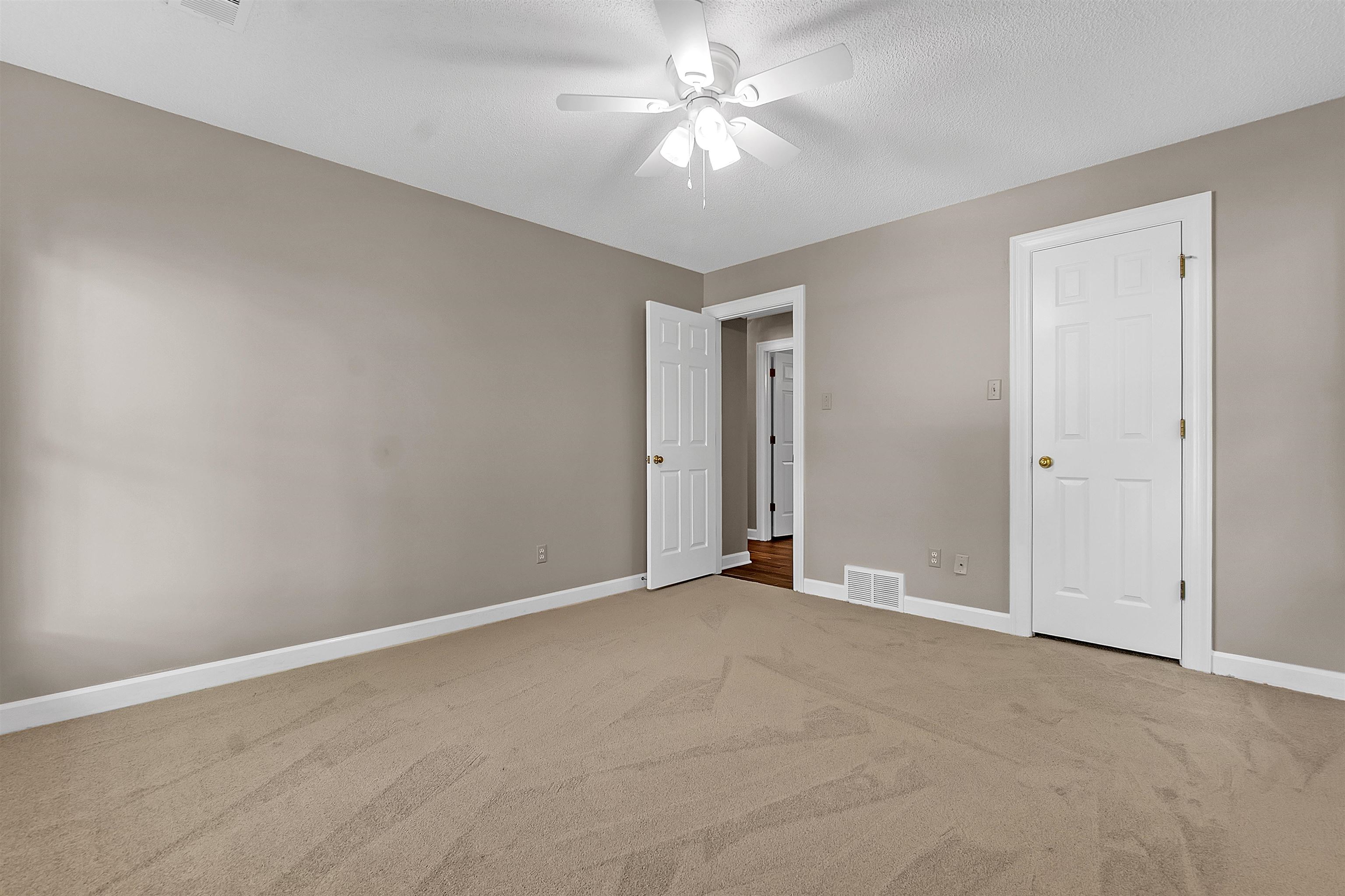 400 Reksten Cove Memphis, TN 38018 - Photo 22 of 26 Carpeted interior space featuring neutral wall tones, white trim, and a ceiling fan with light fixture