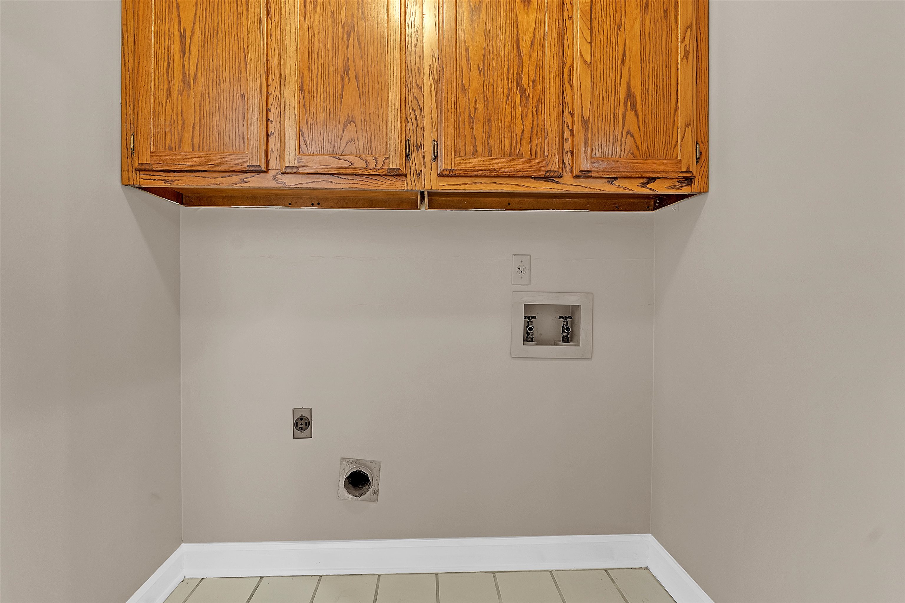 400 Reksten Cove Memphis, TN 38018 - Photo 24 of 26 Laundry area featuring wood cabinetry, light neutral wall paint, and tile flooring