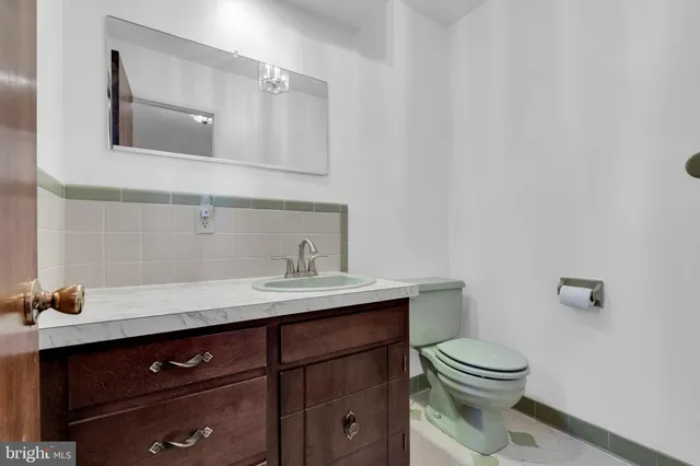 a bathroom with a sink a toilet and mirror
