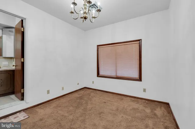 an empty room with a ceiling fan and window