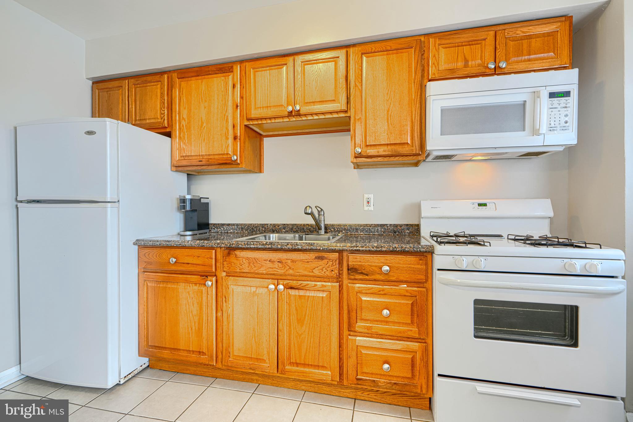 6905 Bank Street Baltimore, MD 21224 - Photo 3 of 17 a kitchen with stainless steel appliances granite countertop a stove a sink and dishwasher