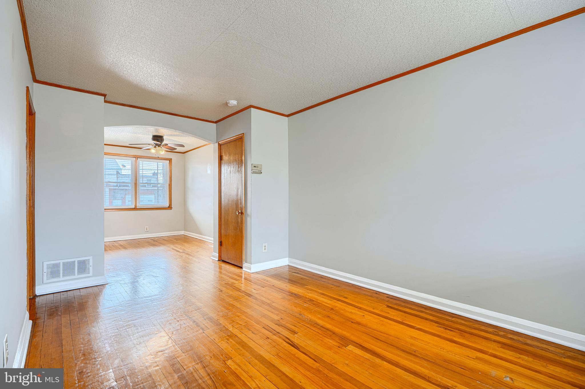 6905 Bank Street Baltimore, MD 21224 - Photo 6 of 17 a view of empty room with wooden floor and fan