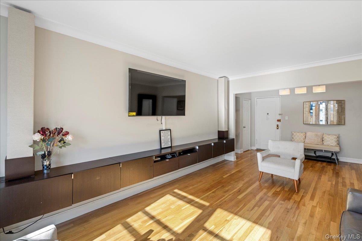 110-45 71st Road, Unit 6D Queens, NY 11375 - Photo 13 of 20 Living area featuring wood finished floors and ornamental molding