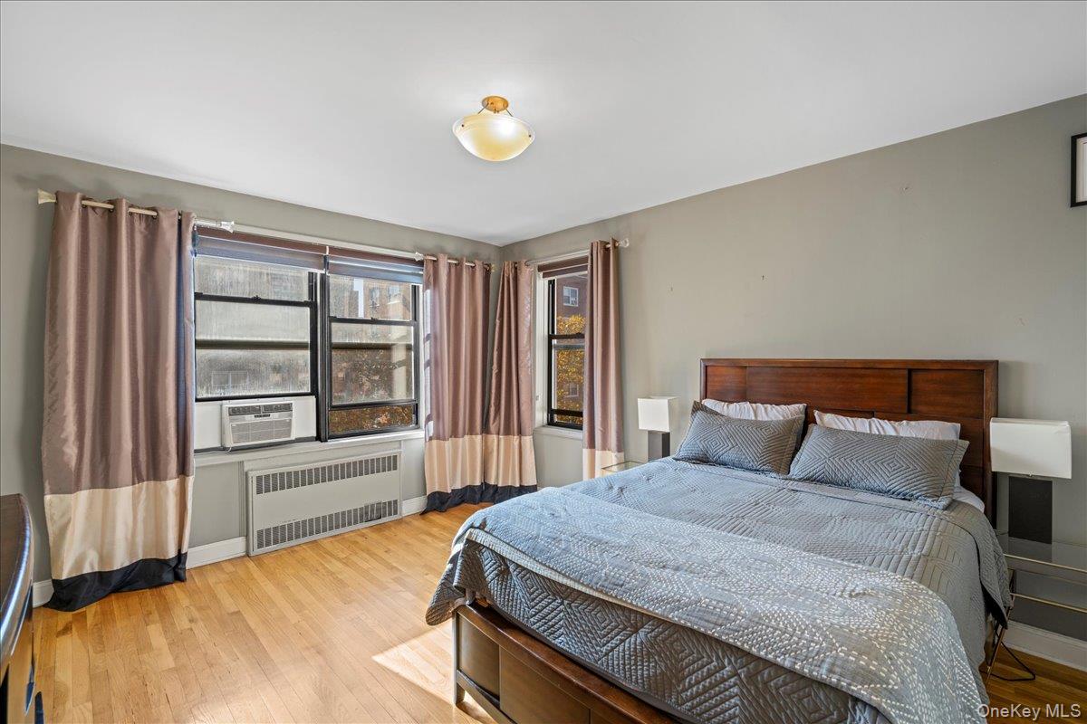 110-45 71st Road, Unit 6D Queens, NY 11375 - Photo 5 of 20 Bedroom featuring radiator heating unit, wood finished floors, and cooling unit