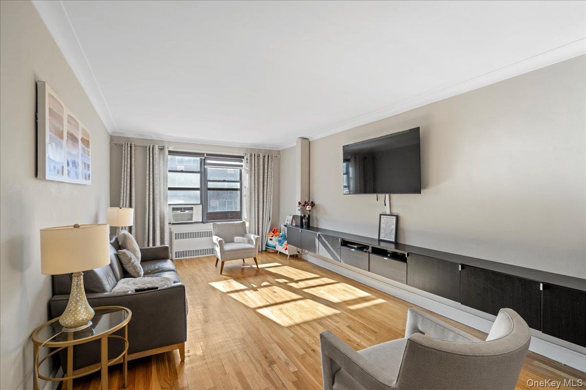 110-45 71st Road, Unit 6D Queens, NY 11375 - Photo 9 of 20 Living room featuring wood finished floors, radiator heating unit, and ornamental molding