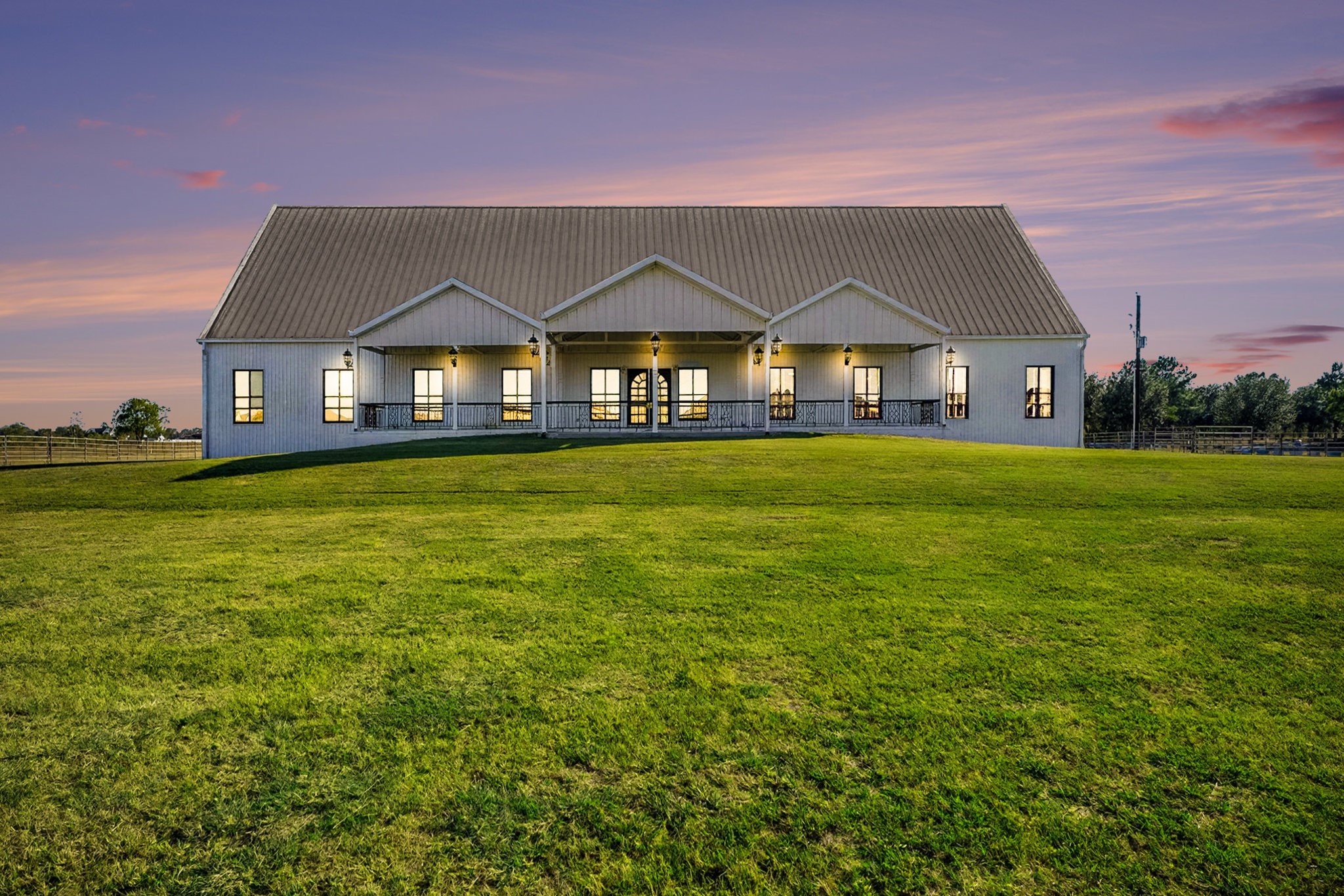 Stunning twilight exterior of estate home showcasing porch lighting and tranquil setting, 1200 Davenport Parkway.