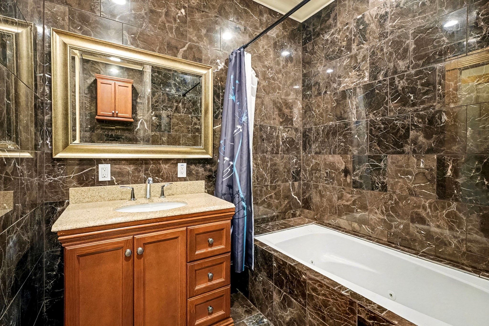 1200 Davenport Parkway Rosharon, TX 77583 - Photo 14 of 49 Office bathroom featuring rich marble tile walls, soaking tub with shower, and elegant
vanity with granite countertop.